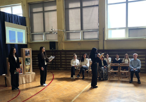 Recytacja wiersza, w tle rada pedagogiczna